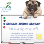 Dog over a sign for pet supply donations for Settle Animal Shelter